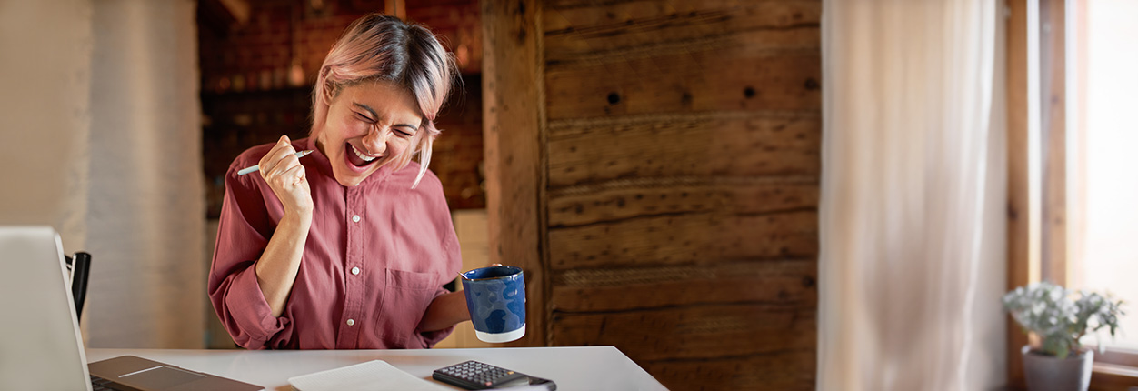 Frau mit Kaffee am Laptop
